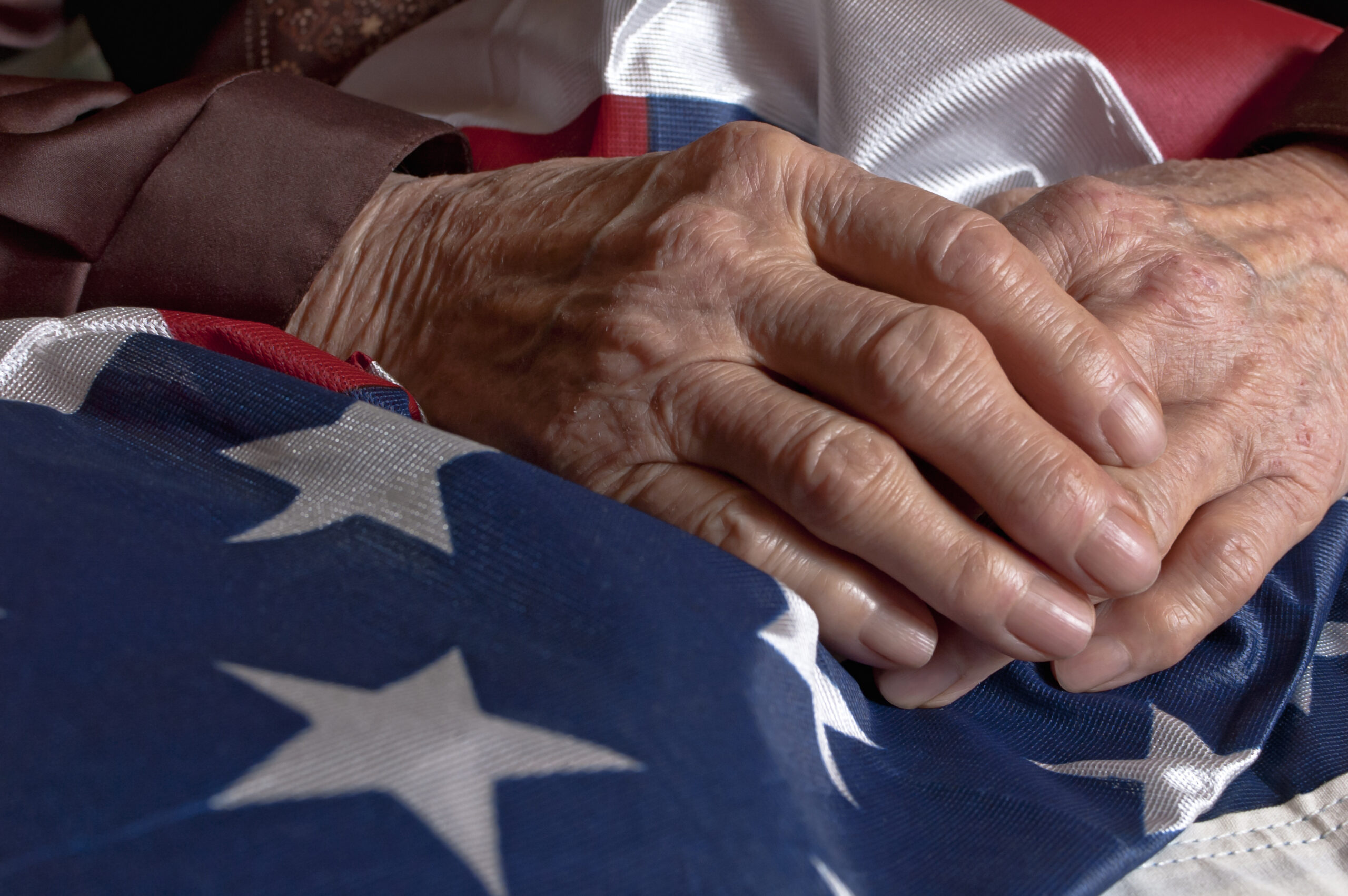 Old person's hands holding an American flag