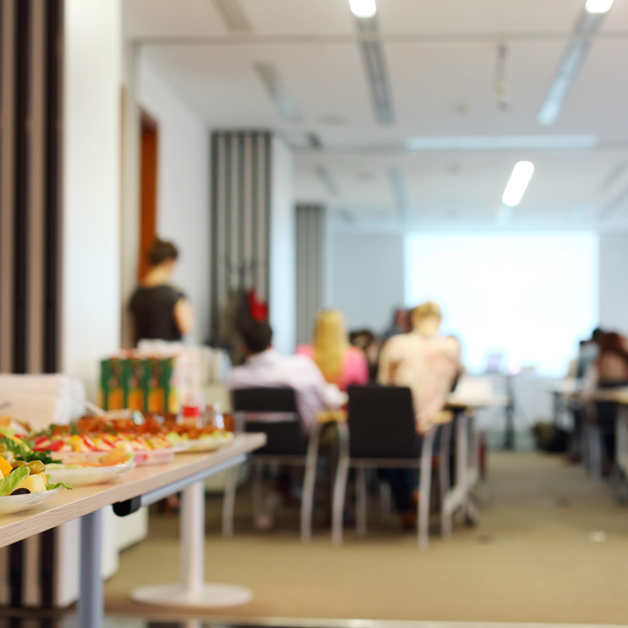 Table with cold snacks and refreshments for business meeting. Focus on food.