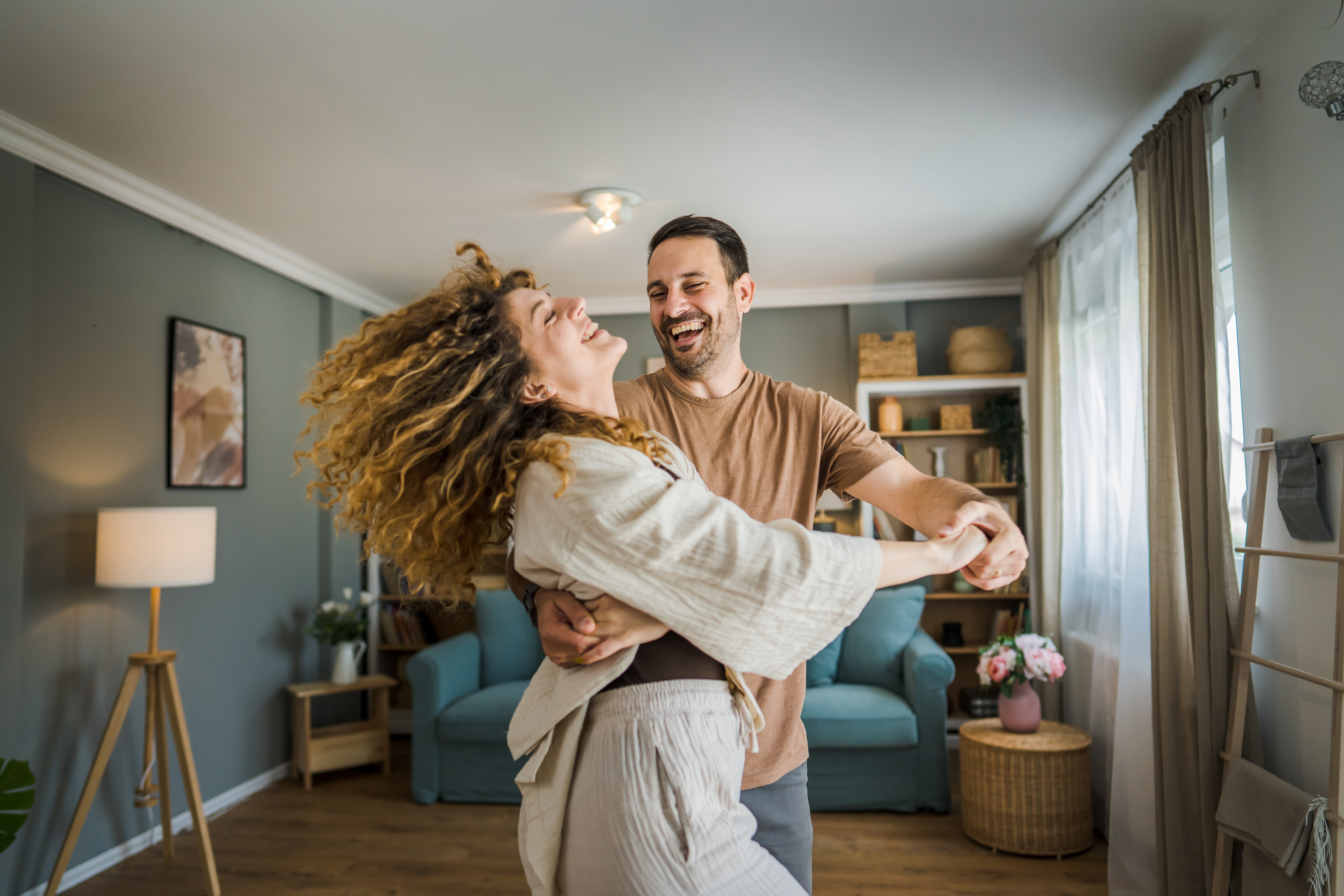 Happy couple adult caucasian man and woman husband and wife dance at home