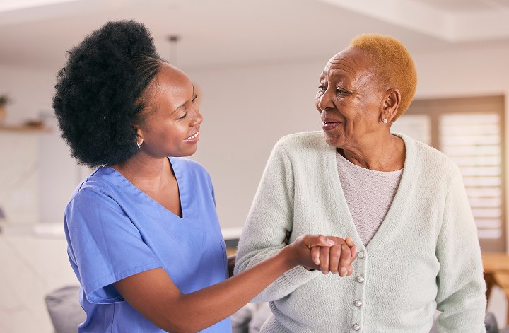 nurse helping elderly woman walk
