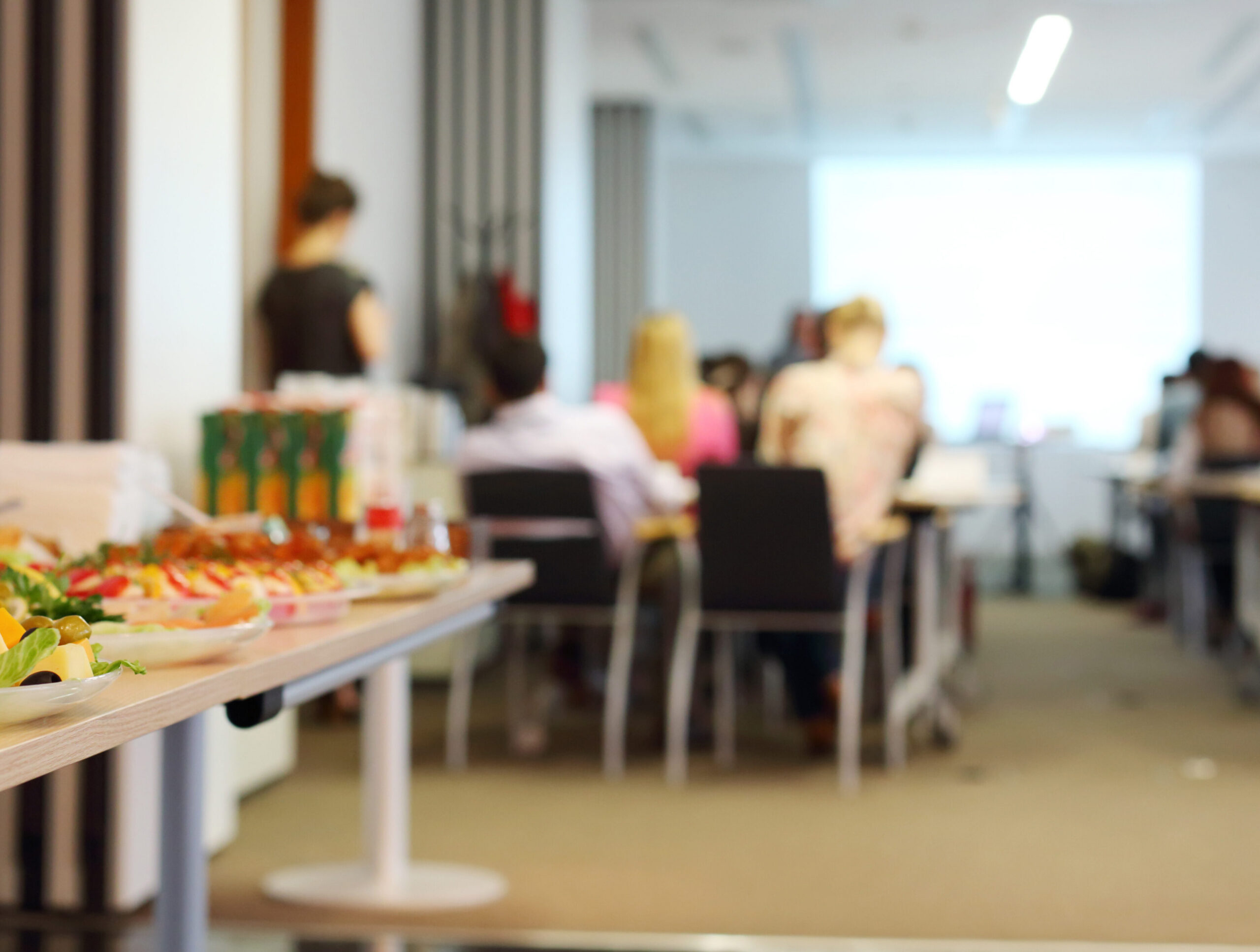 Table with cold snacks and refreshments for business meeting. Focus on food.
